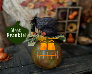 This is a dried gourd carved into a monster themed Halloween pumpkin with a candle. His name is Frankie and wears a custom made top hat.